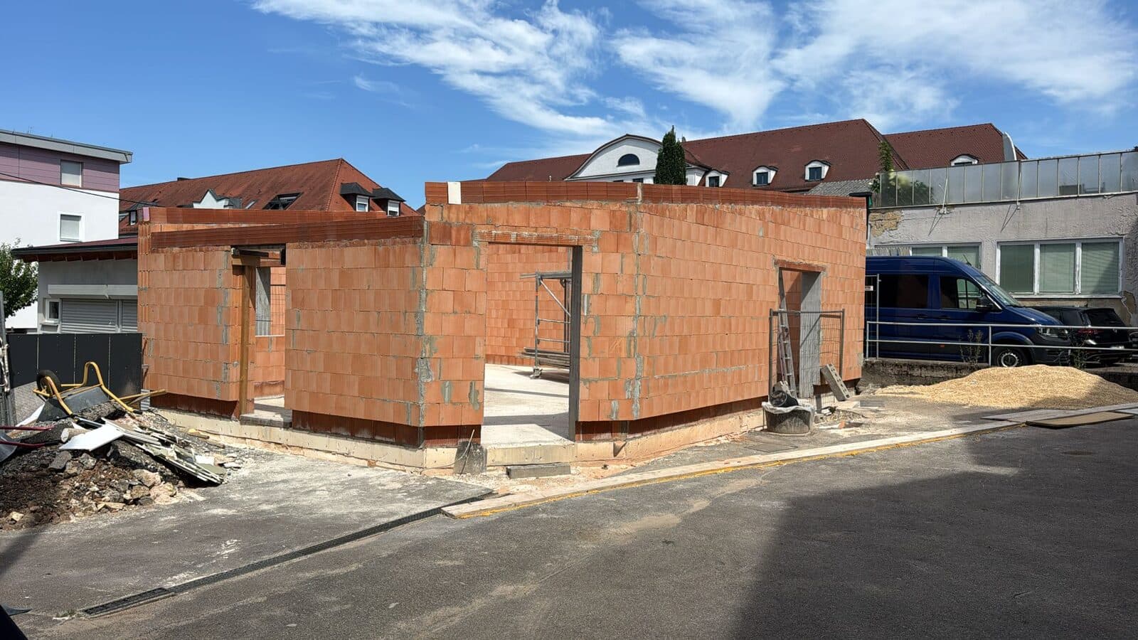 Der Neubau im Rohbau: Ziegelwände bis zur vollen Höhe, Öffnungen für Türen und Fenster