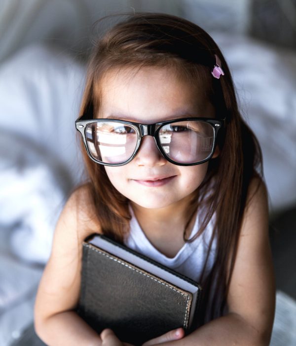 Preschooler girl with books and glasses. teaching, student, education